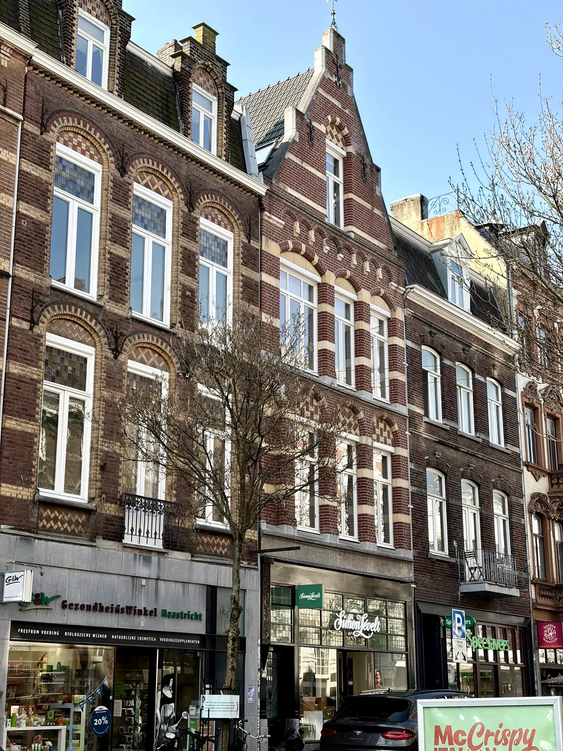 Tall brick building with ground-floor shops in Wyck