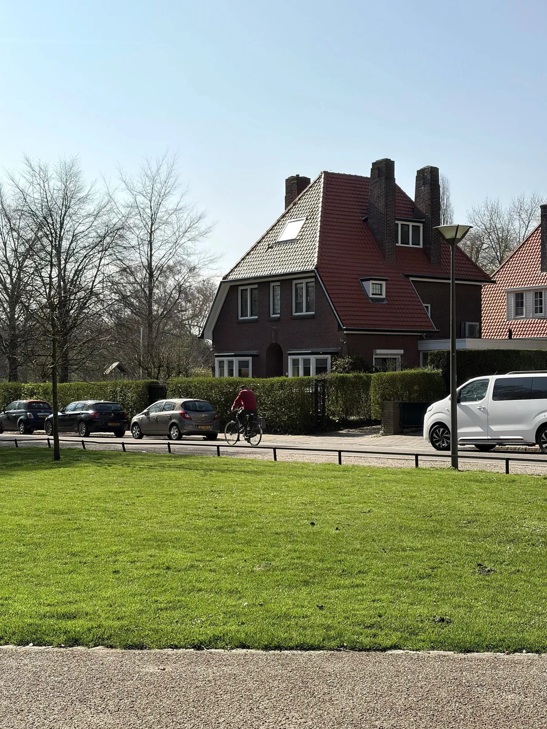 White house above a low wall beside a quiet road near Stadspark