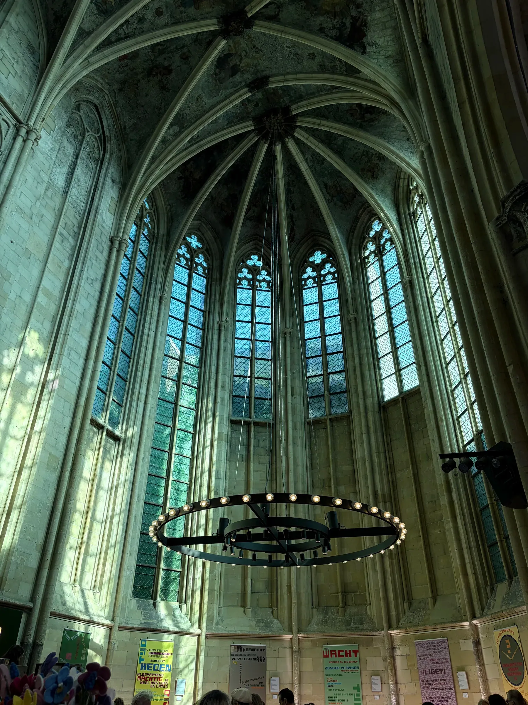 Tall Gothic windows and circular light fixture inside Boekhandel Dominicanen