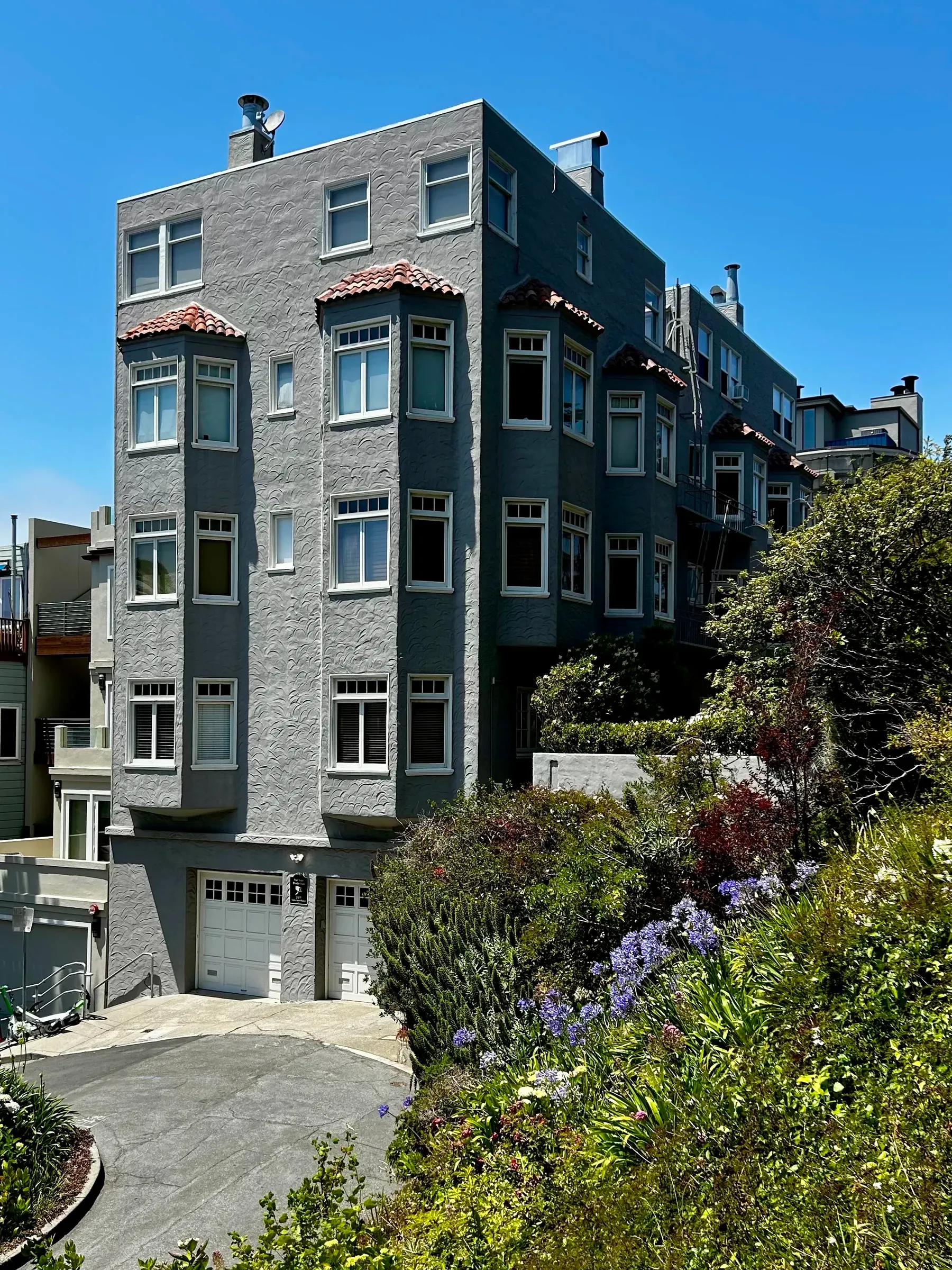 Steep North Beach street with flowers and the downtown skyline beyond