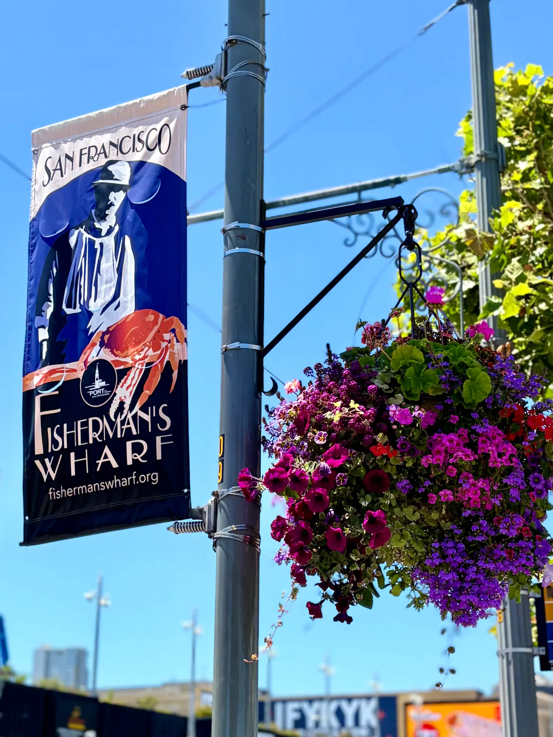 Historic Fisherman's Wharf crab wheel emblem sign framed by flowers
