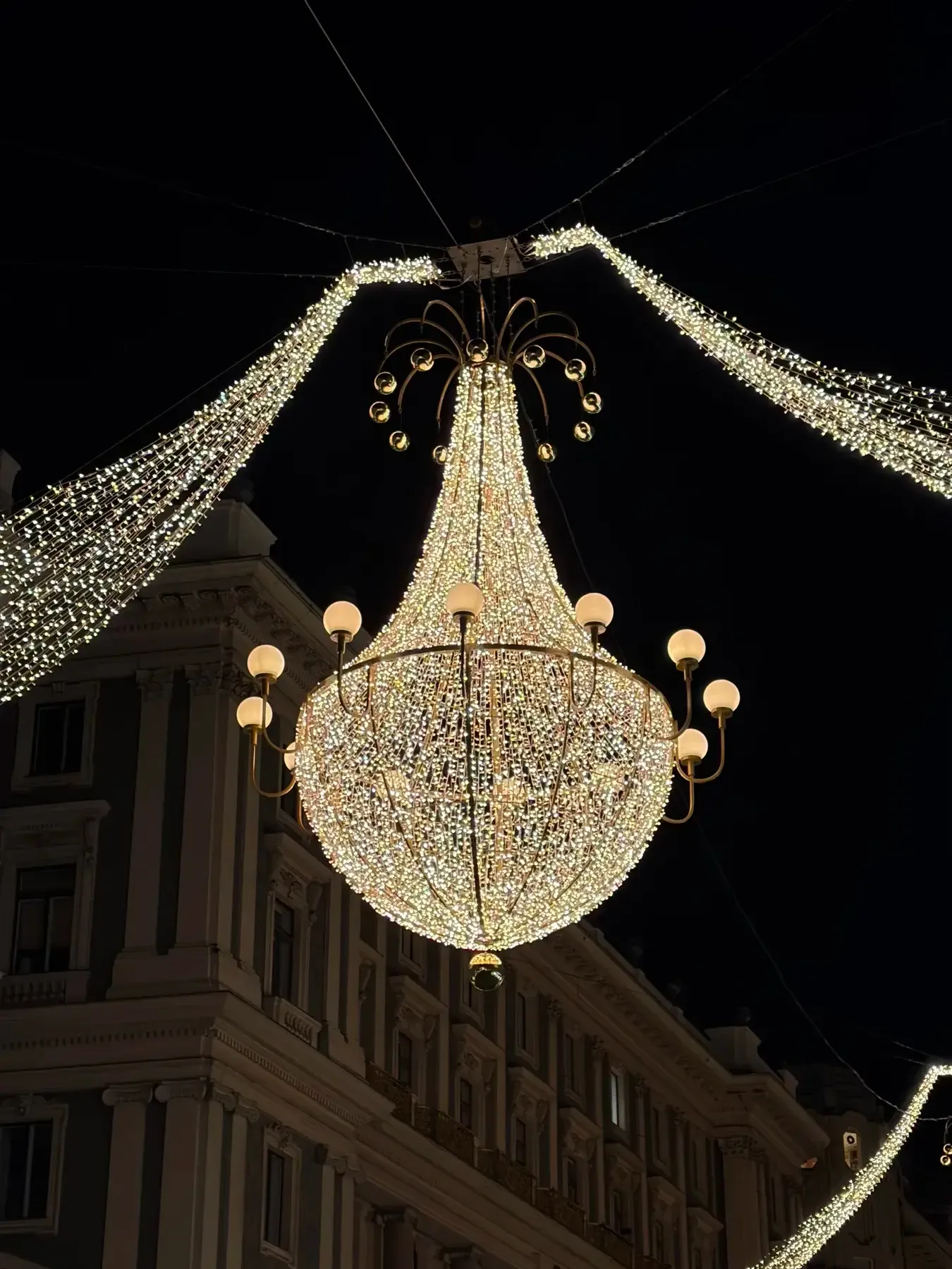 Chandelier-shaped Christmas light hanging above a Vienna street