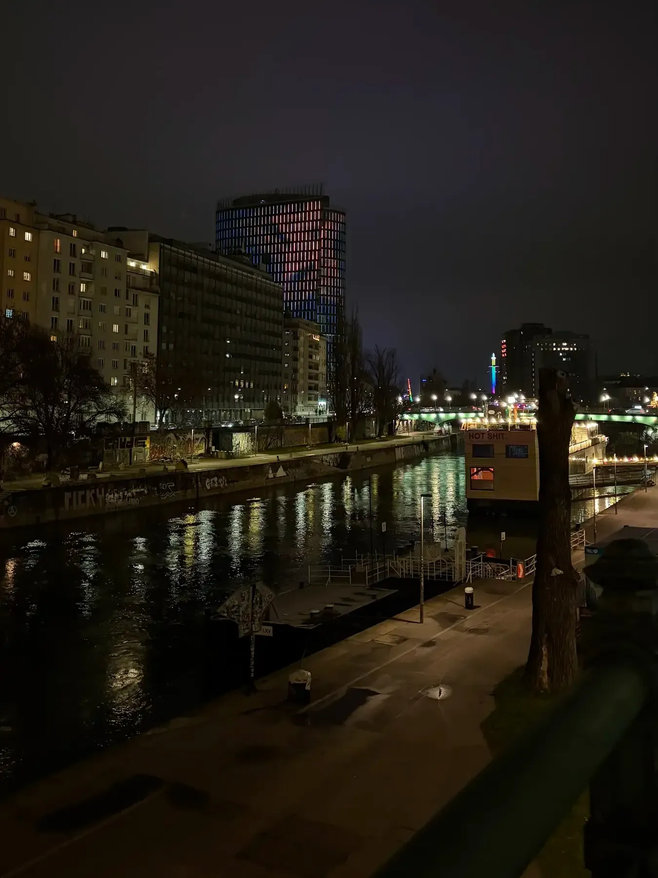 Canal promenade and skyline reflected on the Donaukanal