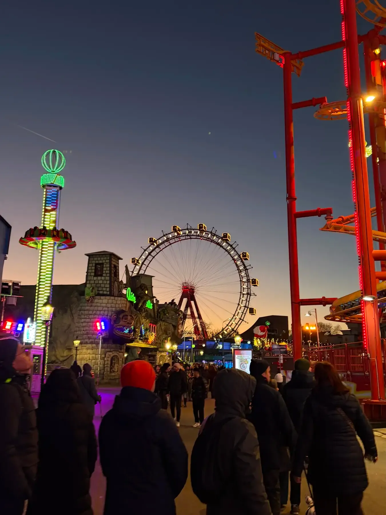 Winter evening crowd among illuminated Prater amusement rides