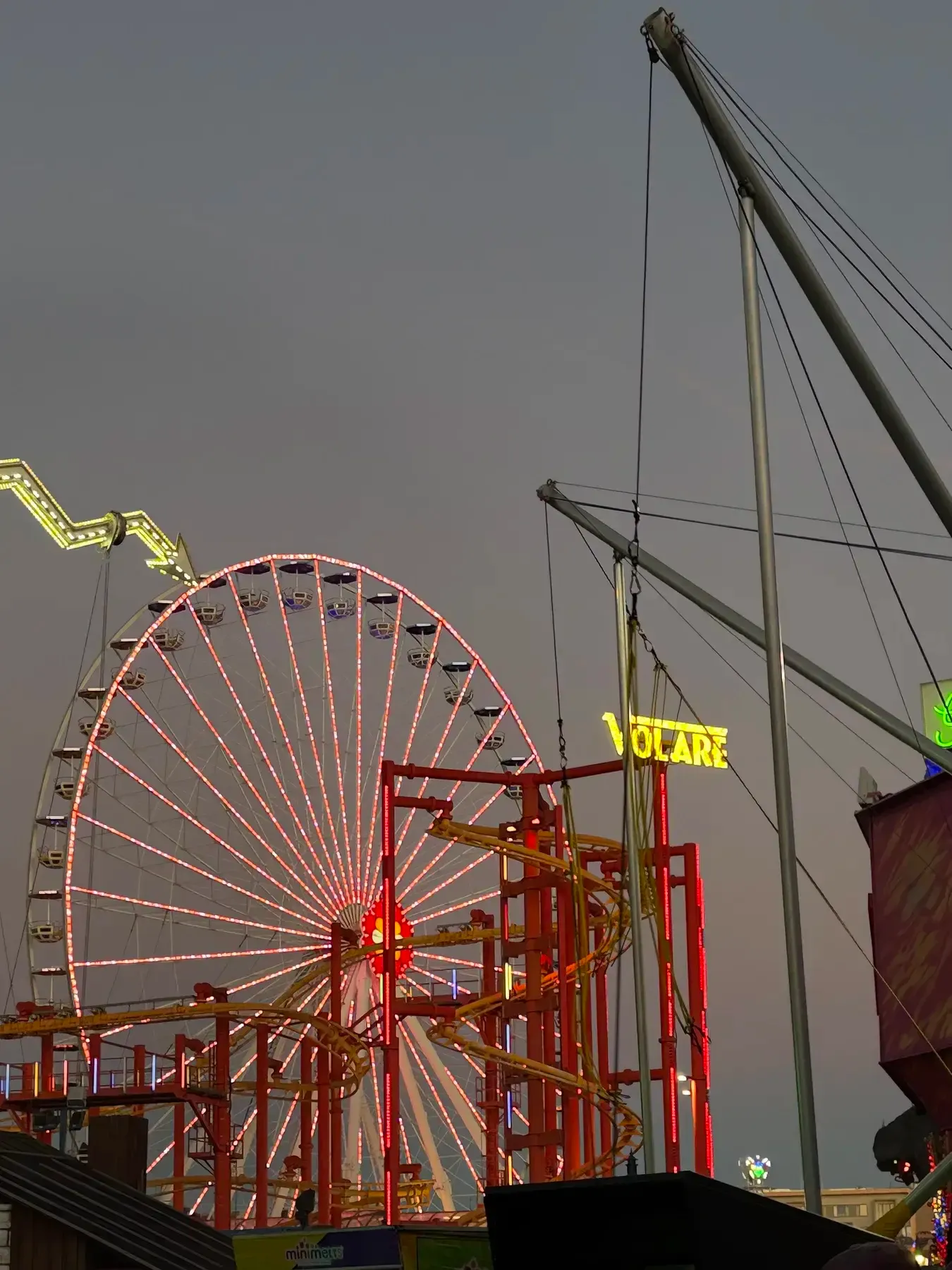 Giant Ferris Wheel seen behind red Prater ride structures