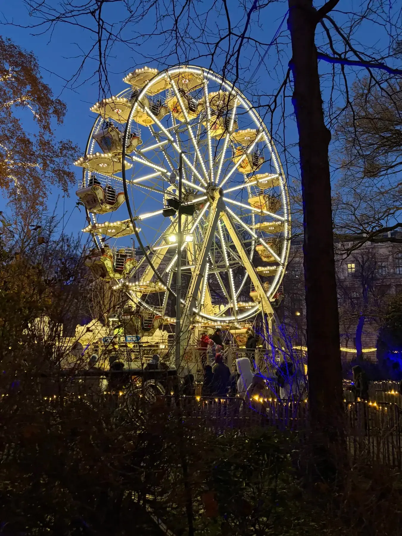 Ferris wheel lit in the Rathauspark at dusk