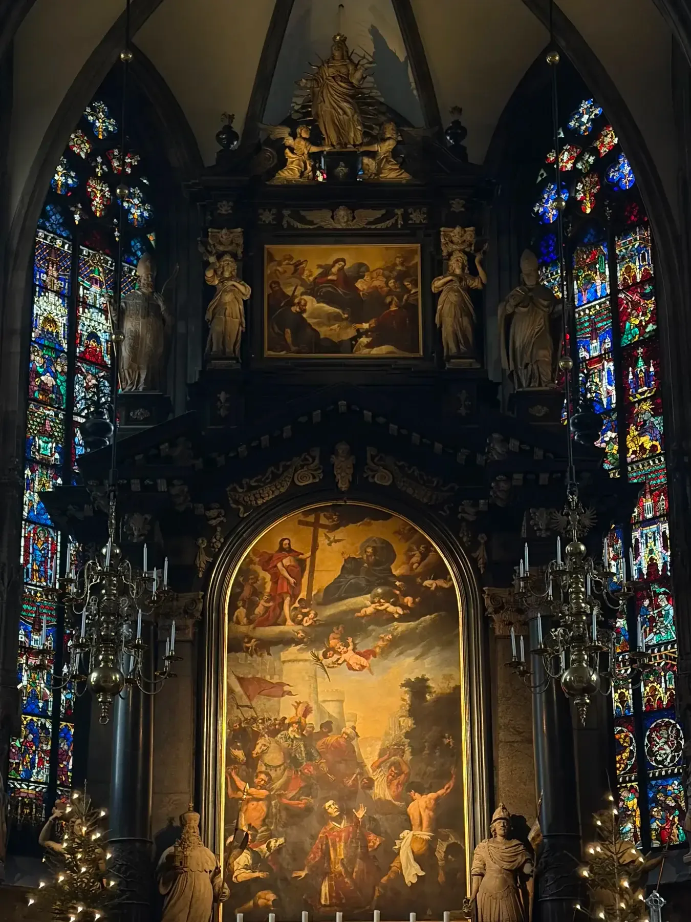 Painted high altar framed by stained glass inside Stephansdom